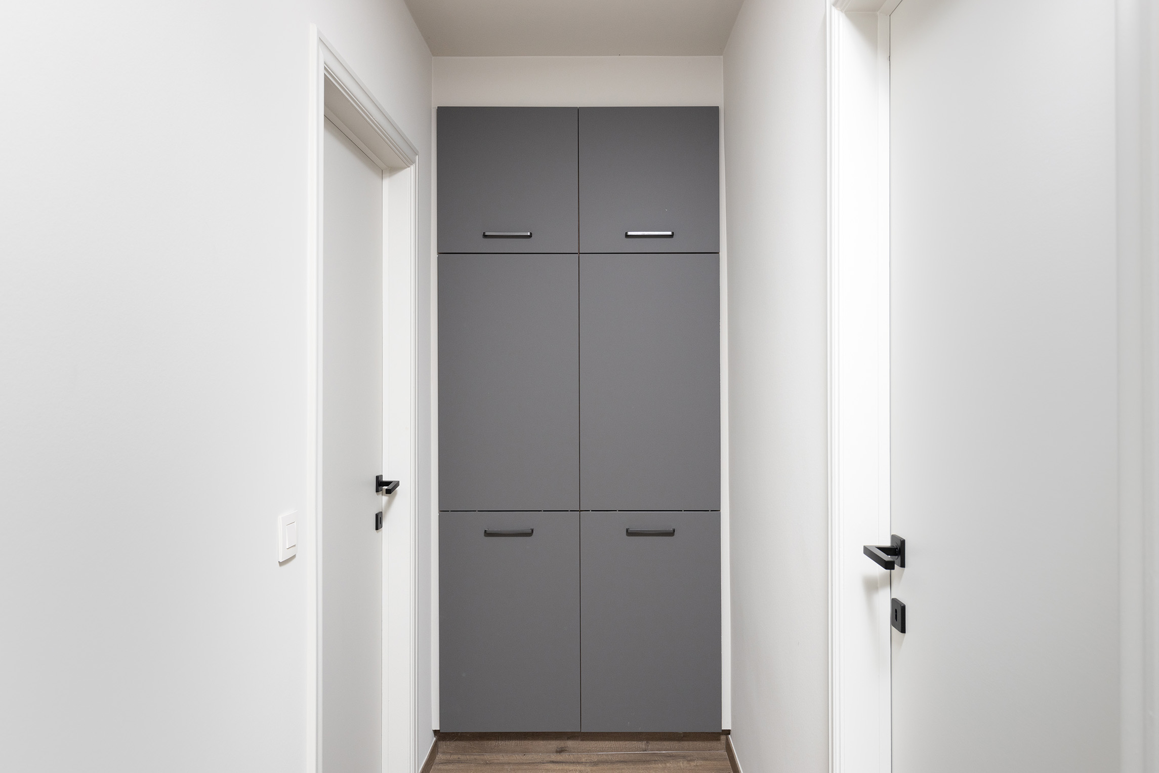 Een hal met ingebouwde kasten die perfect op maat zijn van de ruimte.