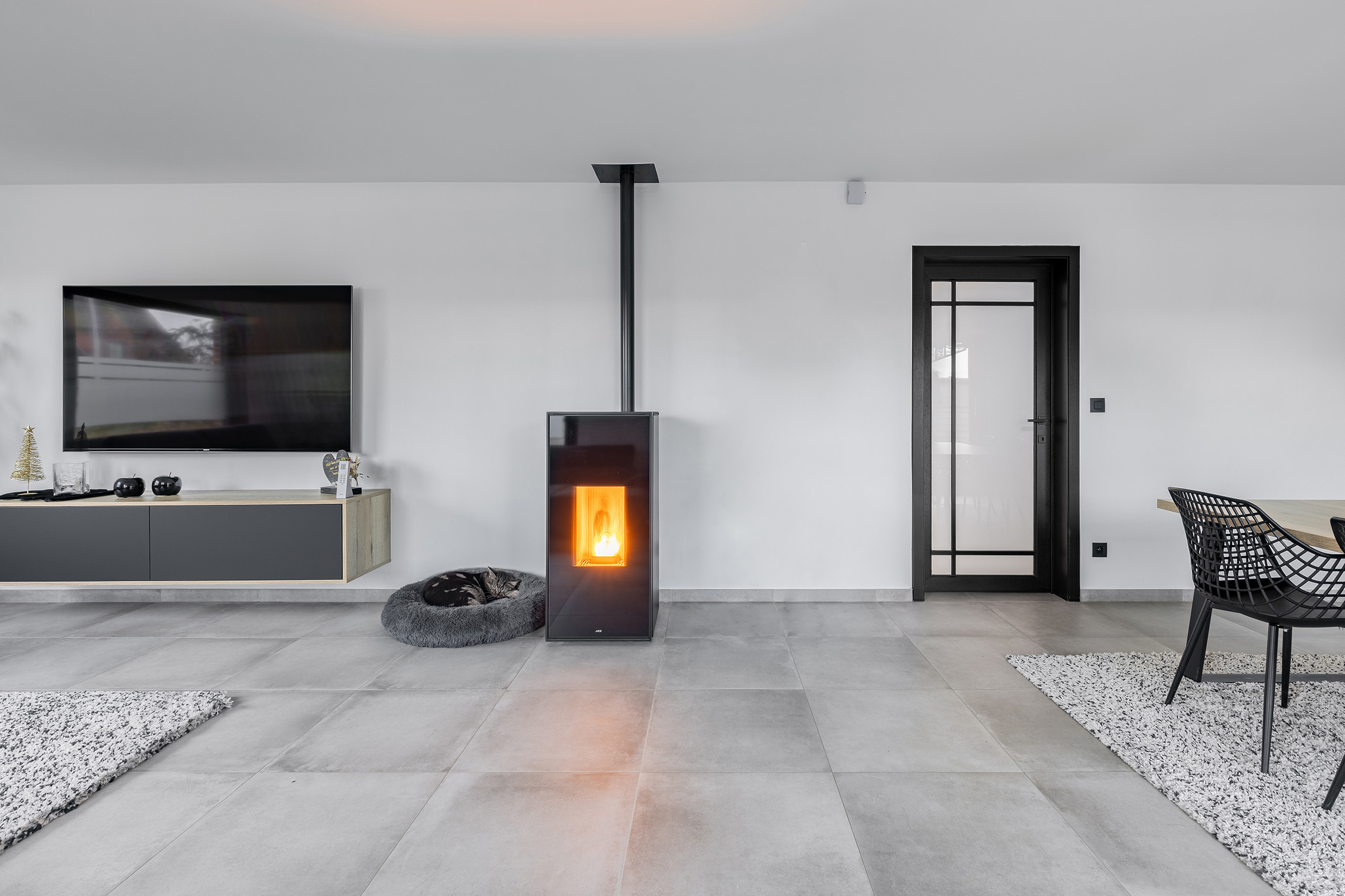 In een gezellige leefruimte met tegelvloer ligt een kat te slapen.